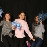 three friends jumping with pom poms